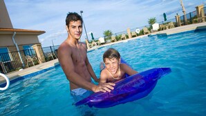 Ein Schwimmbecken mit zwei Personen, eine davon hält einen blauen Schwimmreifen.