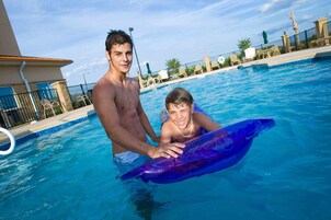 Una piscina al aire libre, sillones reclinables de piscina