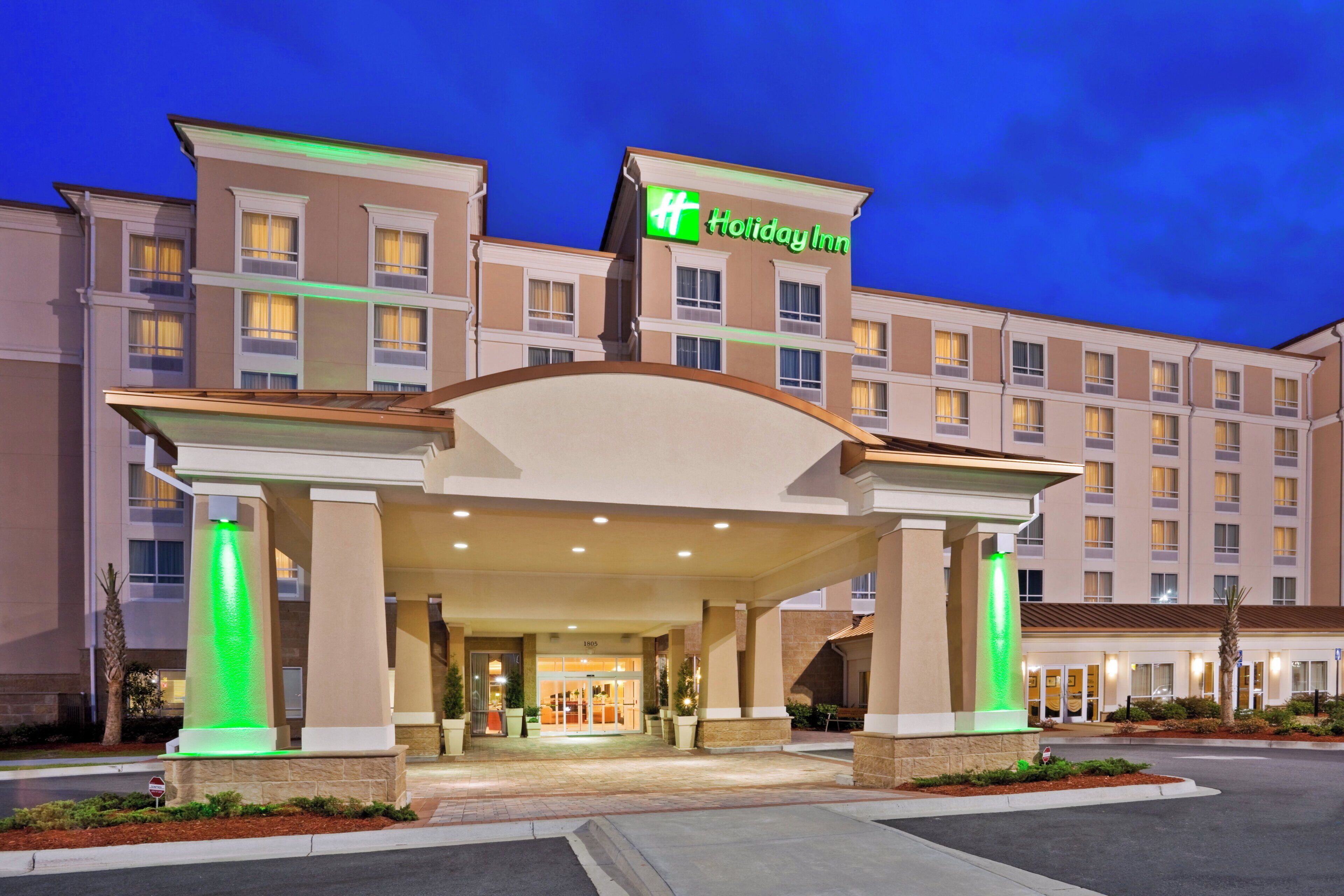 A Holiday Inn hotel entrance with a covered walkway and a sign above the entrance.