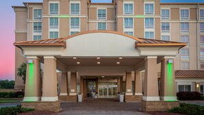 L’entrée d’un hôtel Holiday Inn, dotée d’un design moderne, avec une grande porte en verre et un espace d’entrée abrité.