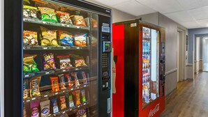 A vending machine with snacks and a Coca-Cola machine in a hallway. - Extended Stay America Select Suites - Las Cruces (Las Cruces)