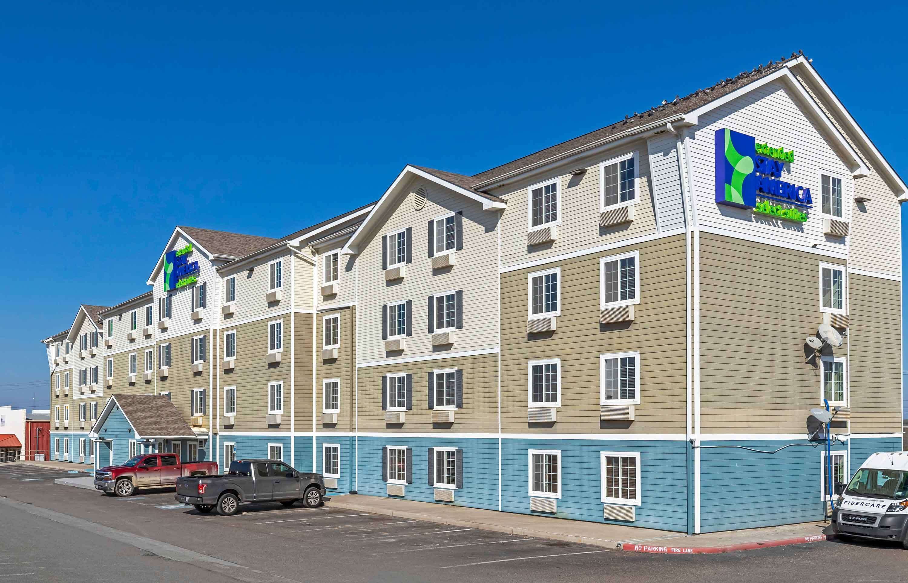 A multi-story hotel with a flat roof, large windows, and a sign for 'Worldly Stay' and 'Hibernia Suites'.