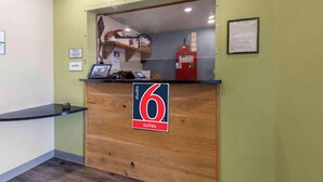 Een receptiebalie met een bordje '6 suites', een computer en een brandblusser.
