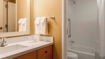 A bathroom with a white sink, mirror, and towel rack.