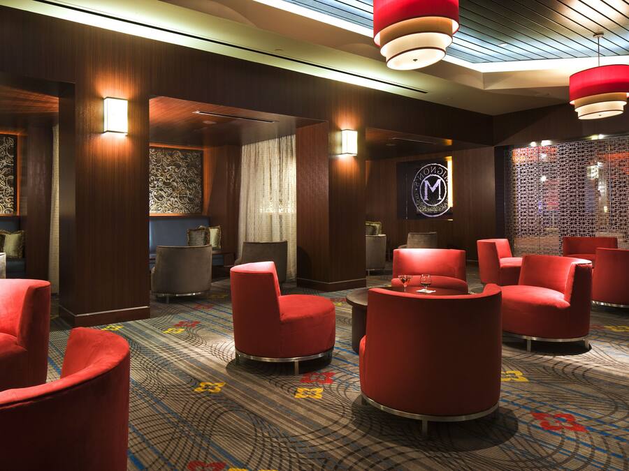 A hotel lobby with red seating, patterned walls, and a reception area.