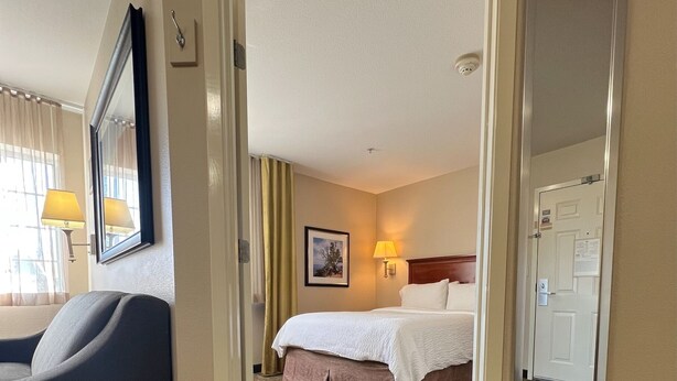 A hotel room with a bed, a desk, a chair, a lamp, and a mirror. - Candlewood Suites Wichita Falls at Maurine Street by IHG (Wichita Falls)