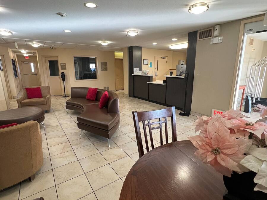 A spacious living area with a dining table, sofas, and a kitchen area in the background.