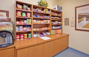 A self-service kiosk with a coffee machine and various snack options.