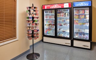 Exposição com diversos produtos alimentares em um corredor de loja.
