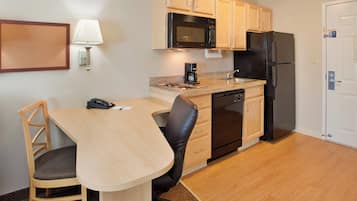 A compact kitchen with a microwave, refrigerator, and coffee maker.