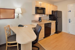 A compact kitchen with a microwave, refrigerator, and coffee maker.