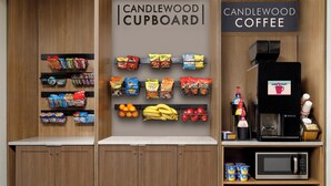 UN GABINETE DE CANDLEWOOD con aperitivos, una máquina de café y un microondas.
