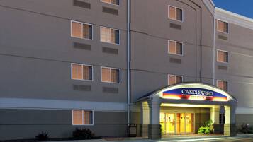A hotel with multiple windows, a prominent entrance with a sign, and a flat facade.