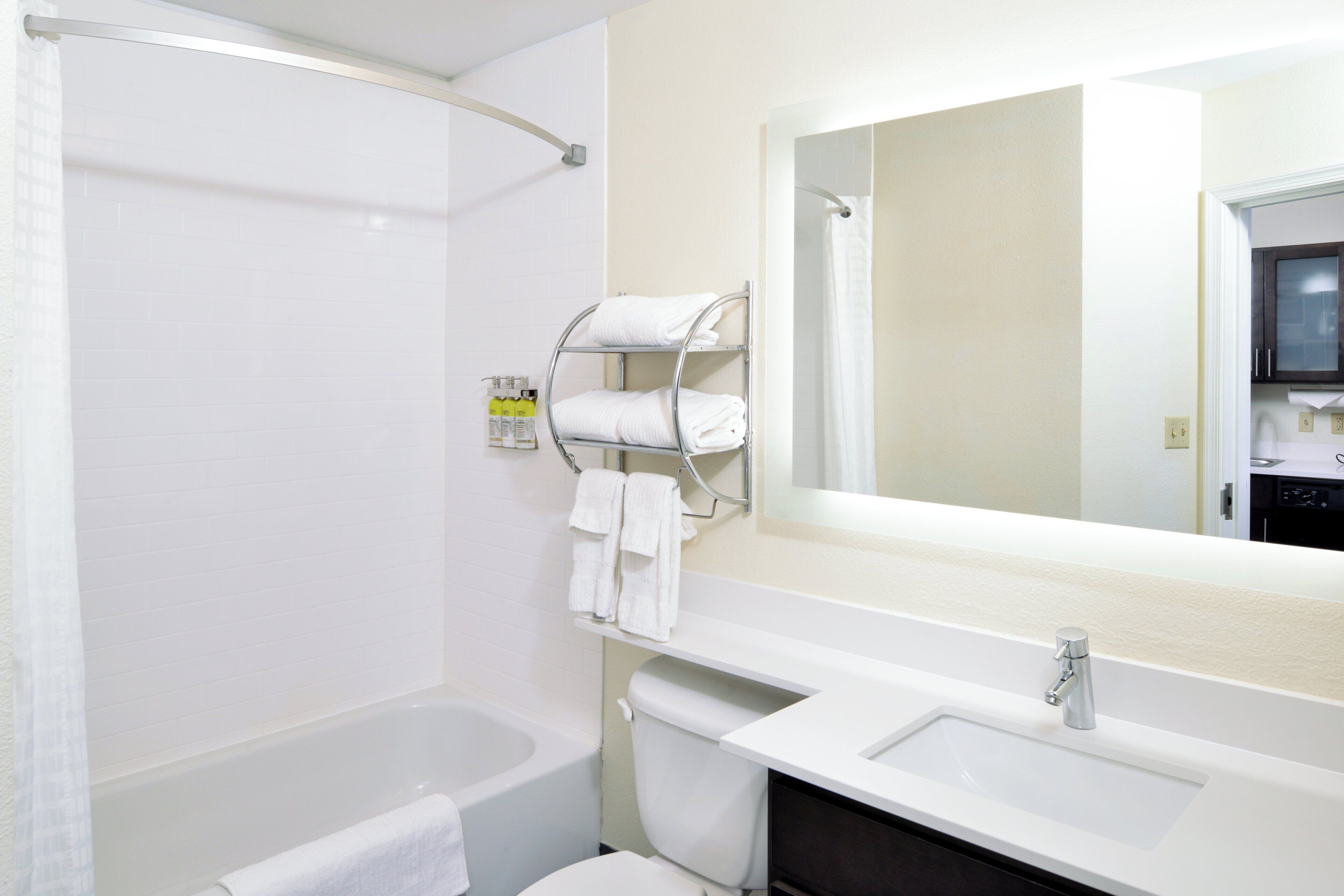 A bathroom with a bathtub, toilet, sink, and a mirror.