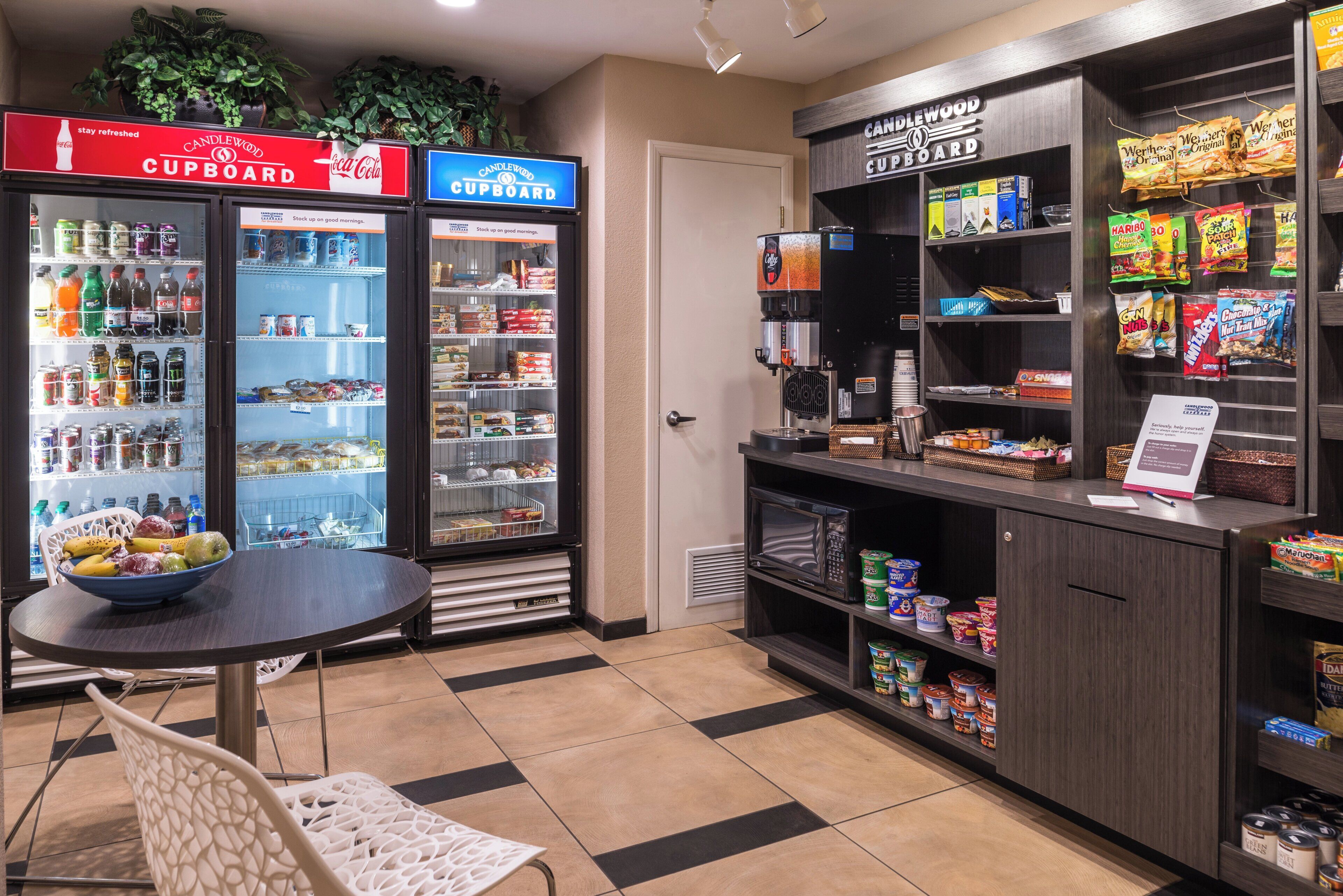 Un área de cocina americana equipada con refrigerador, microondas y cafetera.
