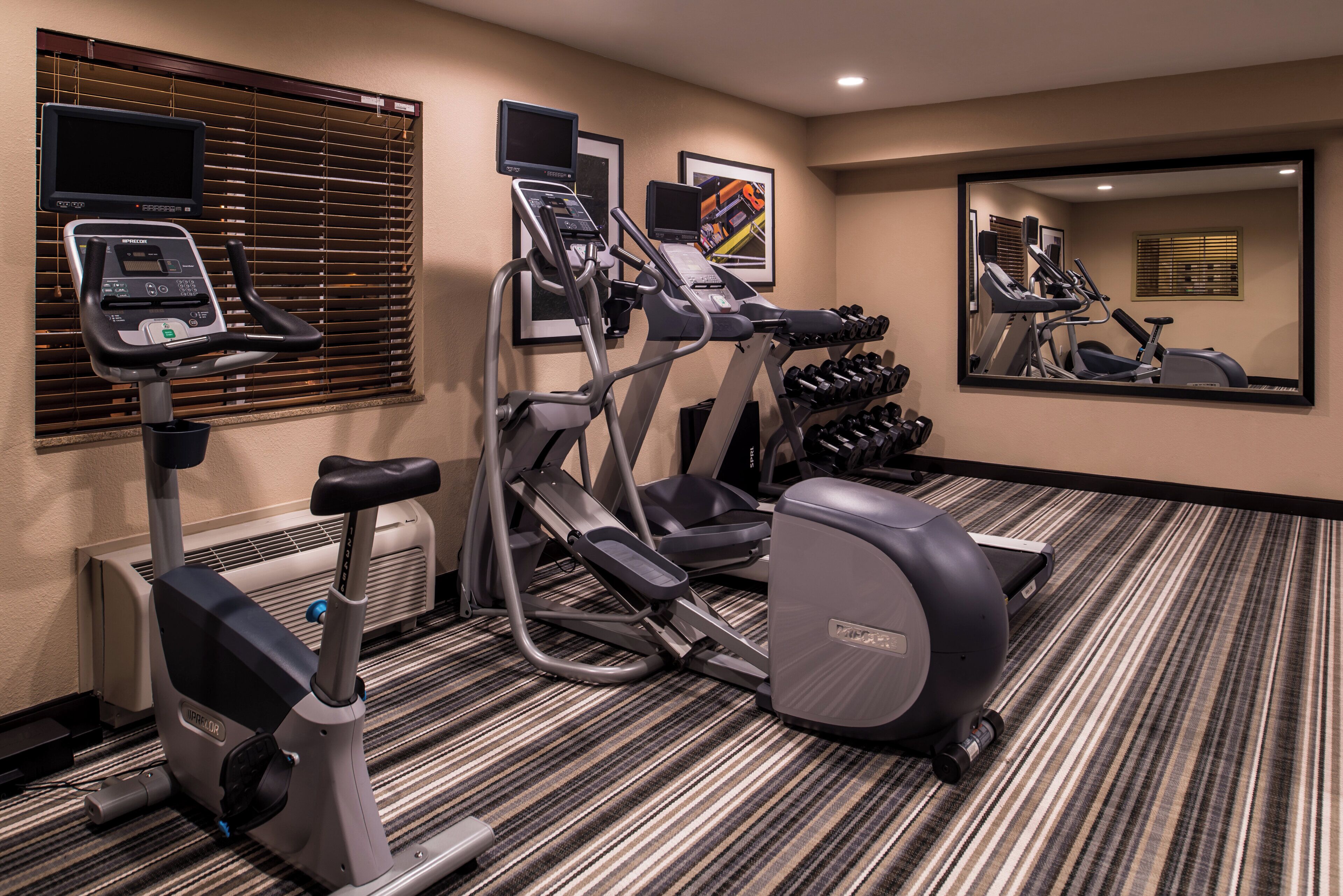 Gimnasio de hotel con cintas de correr, elíptica y escaladora.