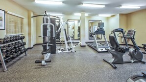 A gym with various exercise equipment including treadmills, elliptical machines, and free weights. - Candlewood Suites Indianapolis Airport by IHG (Indianapolis)