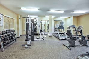 A gym with various exercise equipment including treadmills, elliptical machines, and free weights. - Candlewood Suites Indianapolis Airport by IHG (Indianapolis)