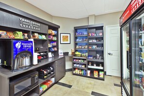 A snack bar with a variety of packaged foods and a coffee machine. - Candlewood Suites Indianapolis Airport by IHG (Indianapolis)