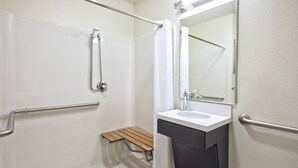 Ein modernes Badezimmer mit Dusche, Waschbecken und Spiegel.