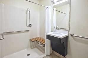 Ein modernes Badezimmer mit Dusche, Waschbecken und Spiegel.