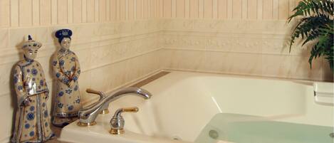 Un baño con lavamanos, bañera y objetos decorativos en el mueble.