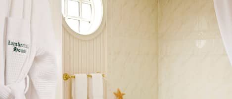 A bathroom with a bathtub, toilet, and a window.