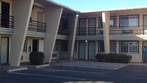 A multi-story hotel with a central courtyard, balconies, and a parking lot. - Budget Inn and Suites El Centro (El Centro)