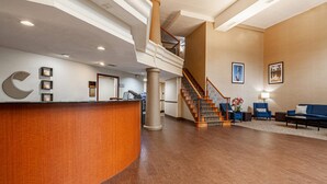 A spacious lobby with a curved reception desk, a staircase, and seating area. - Comfort Suites Morrow - Atlanta South (Morrow)