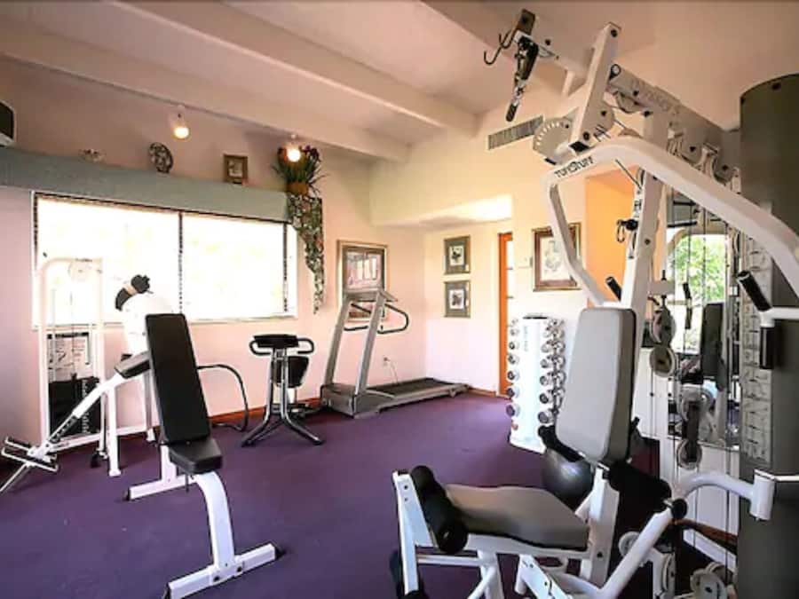 Et fitnesscenter med forskellig træningsudstyr, heriblandt løbebånd, motionscykel og styrkemaskiner.