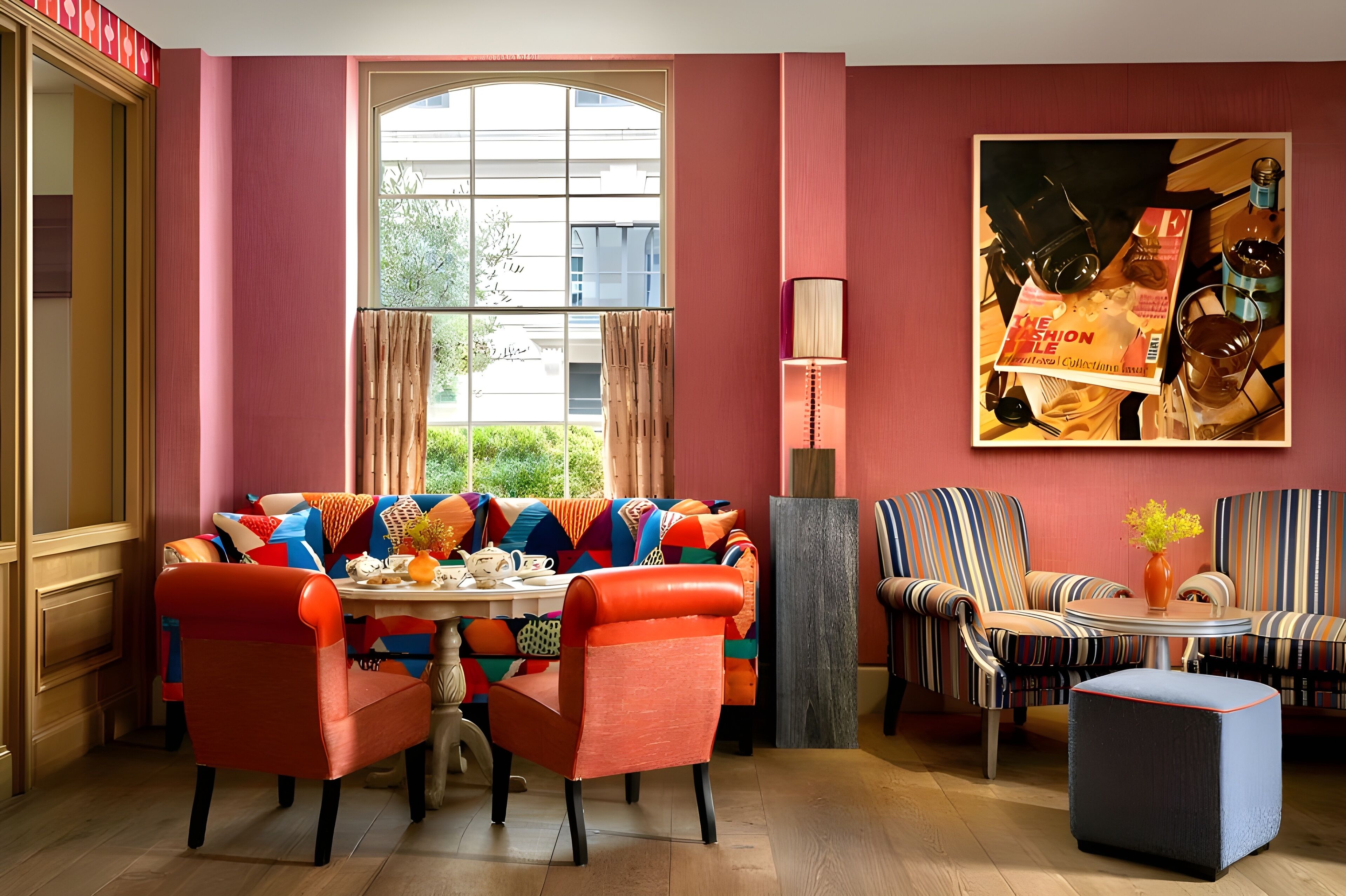 A room with a sofa, chairs, a table, and a large window.