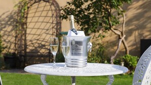 A silver champagne bucket with two glasses on a white table outdoors. - The Claremont (Hove)