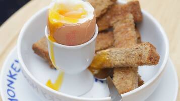 A breakfast plate with a poached egg, toast, and a spoon.