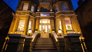 A historic building with a prominent entrance, a staircase, and a sign reading "The Claremont." - The Claremont (Hove)