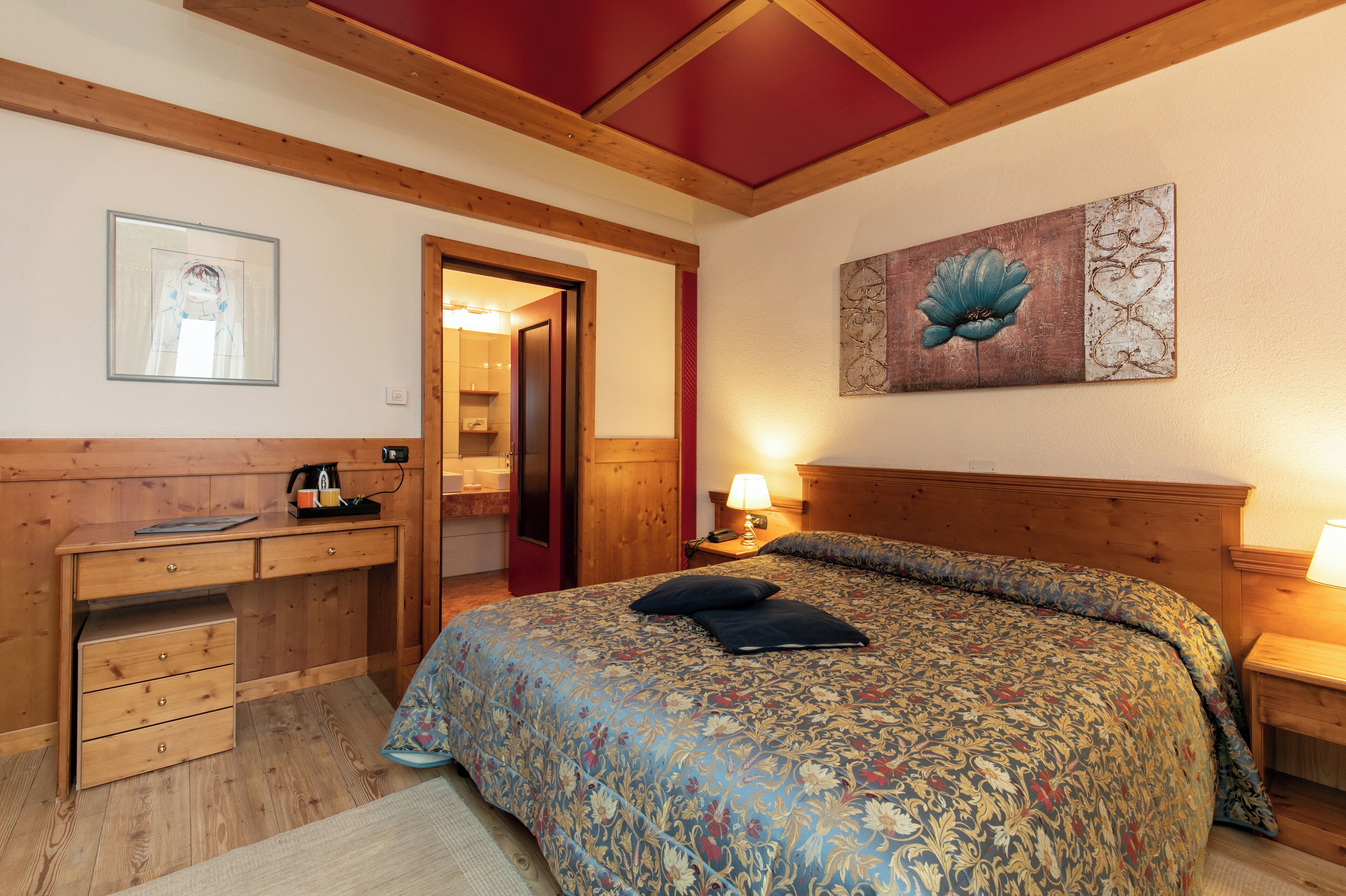 A bedroom with a wooden bed, a desk, and a nightstand.
