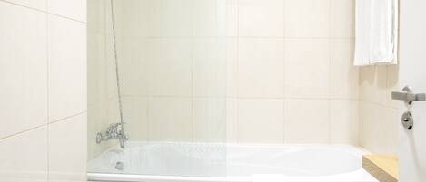 Un baño moderno con bañera, ducha y un perchero para toallas.