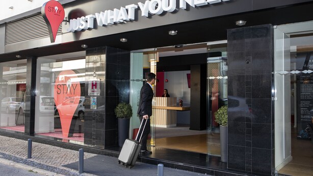 A hotel entrance with a reception desk and a sign that reads "STAY WHAT YOU NEED". - Stay Hotel Faro Centro (Faro)