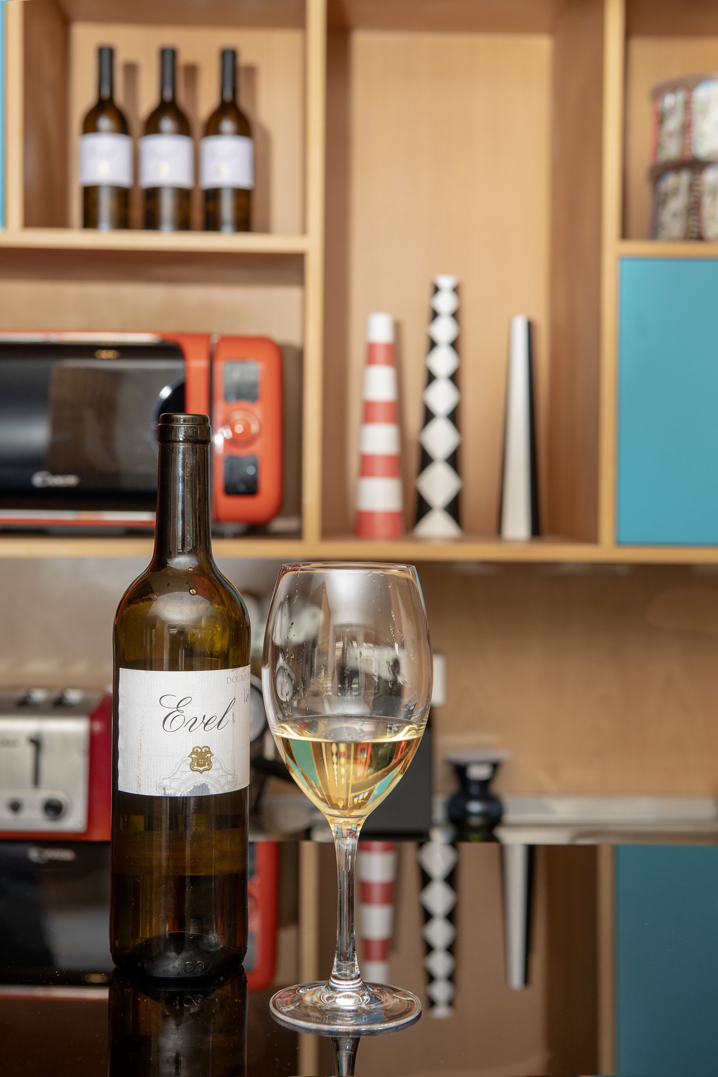 A bottle of wine and a wine glass on a table.