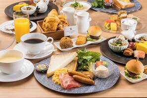 Un buffet de petit-déjeuner proposant divers plats, notamment des œufs, des saucisses et des sandwichs.
