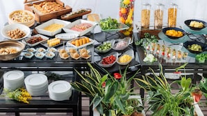 Een buffet met diverse etenswaren en een decoratieve plantenpresentatie.