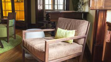 A cozy room with a wooden armchair, a small table, and a bookshelf.