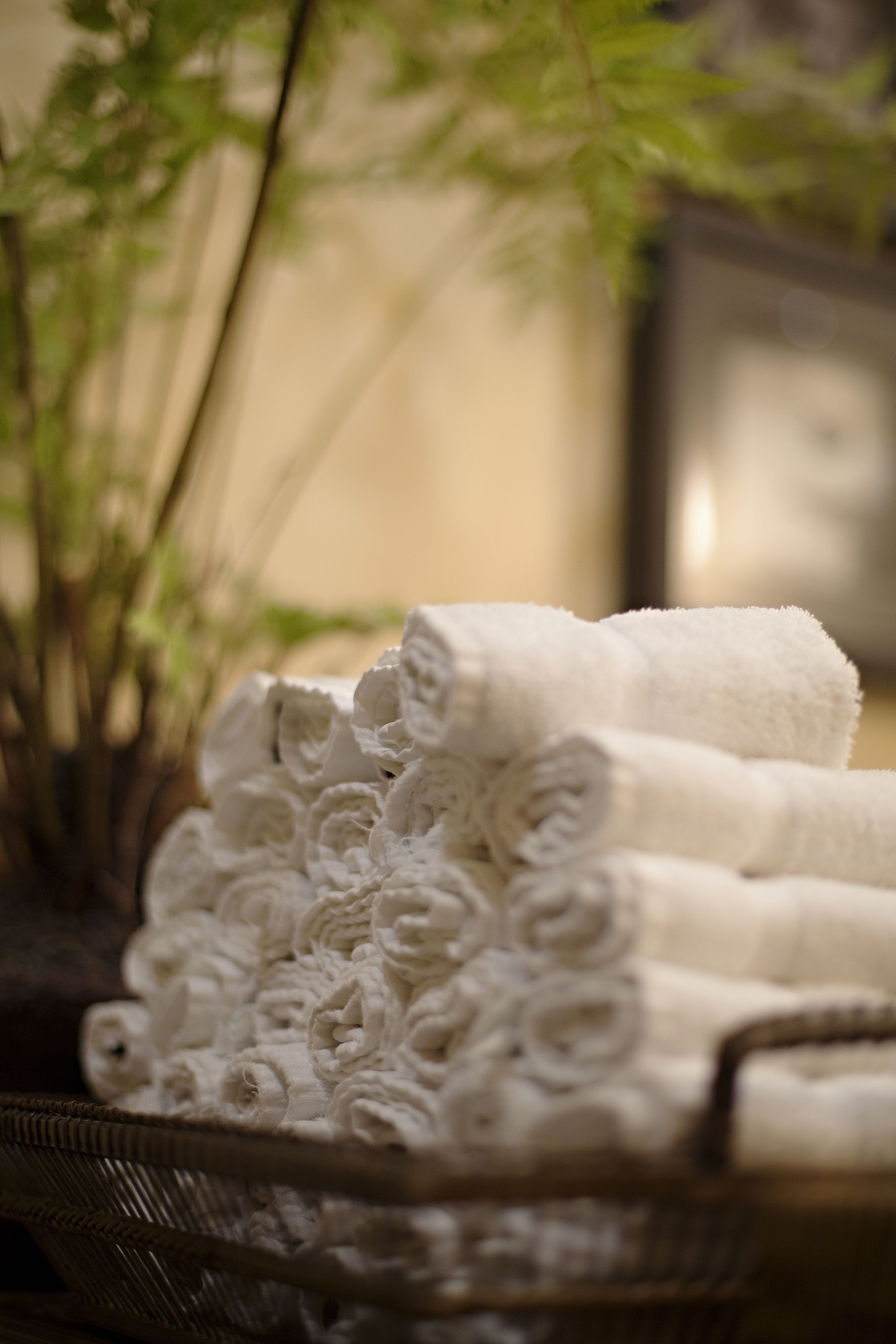 A basket of neatly rolled white towels.