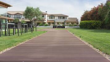 A pathway leading to a building with outdoor seating and a well-maintained lawn.