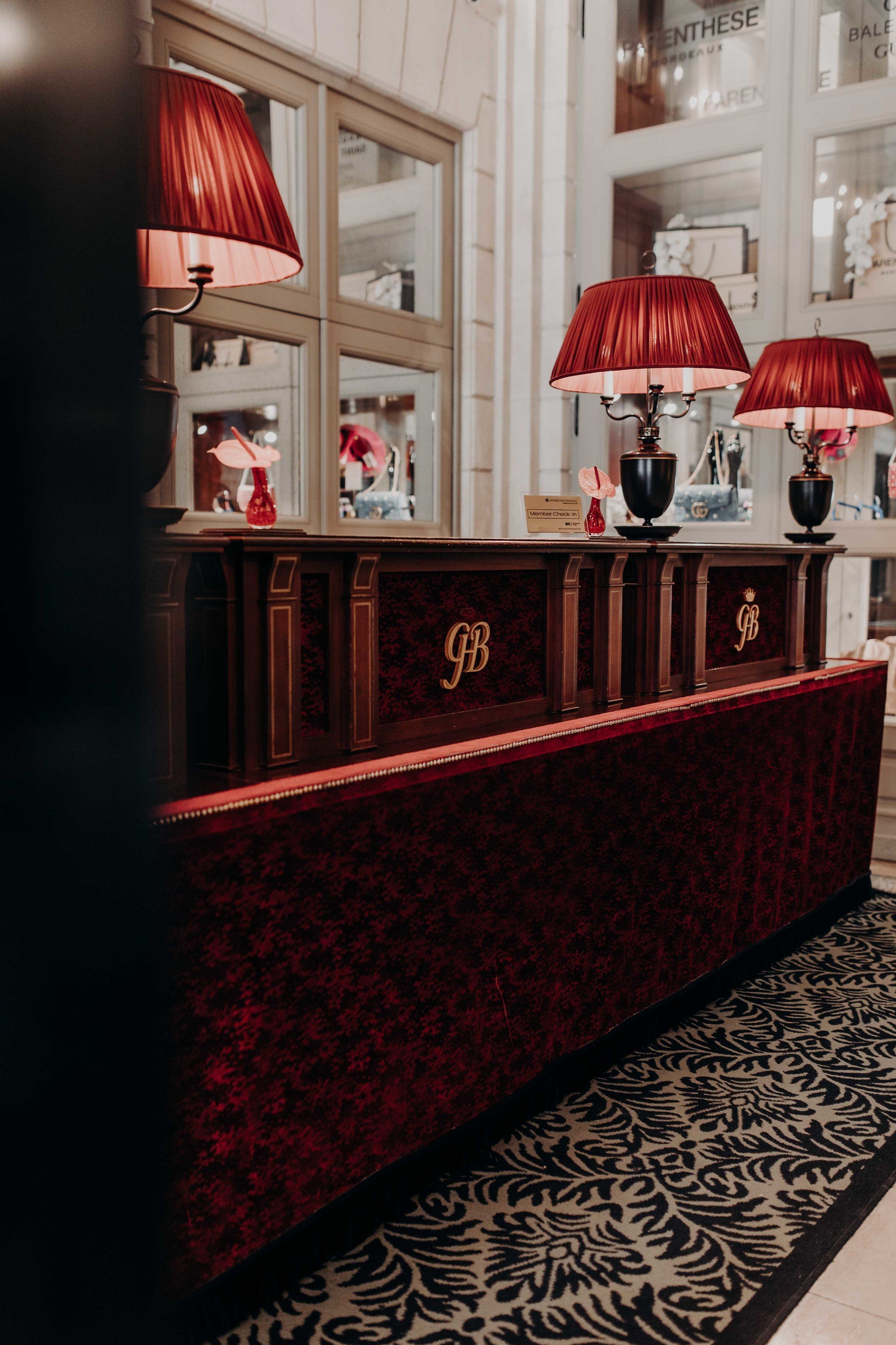A reception desk with red lamps and a patterned carpet.