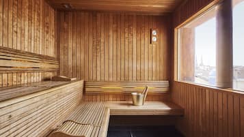 Sauna de fusta amb bancs, un cubell i un rellotge a la paret.