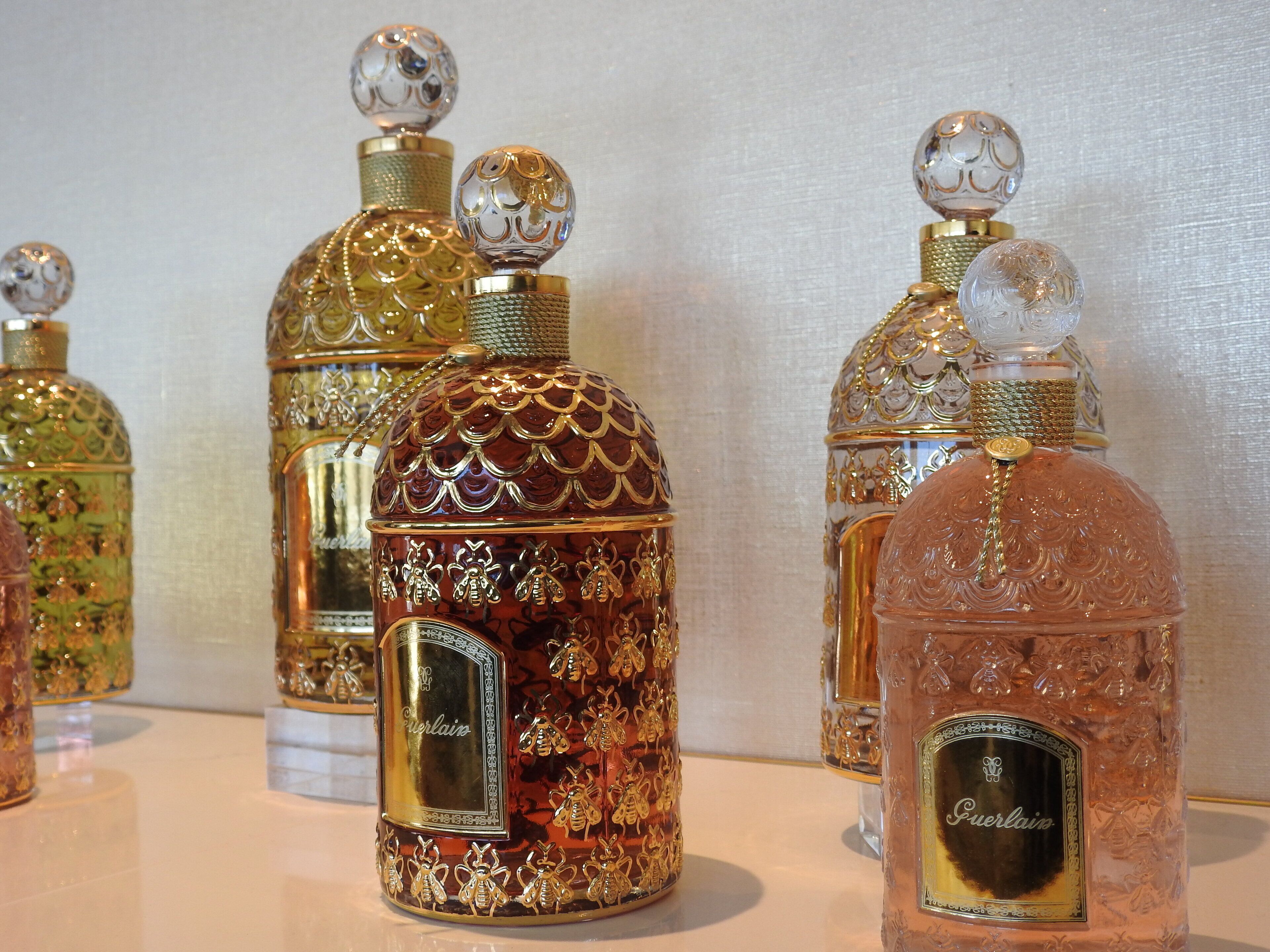 A collection of ornate perfume bottles with intricate designs and labels.