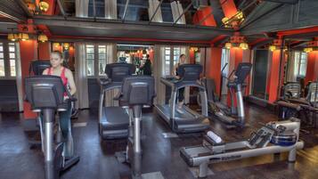 Une salle de sport équipée de vélos d’appartement, de tapis de course et d’un appareil d’aviron.