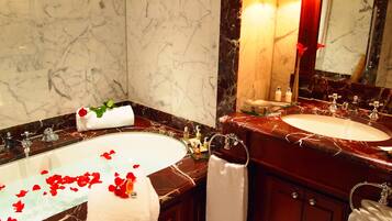 A bathroom with two sinks, marble walls, and a large mirror.