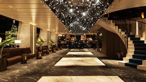 A modern hotel lobby with a marble floor, a staircase, and a city view. - Hilton Istanbul Maslak (Sariyer)