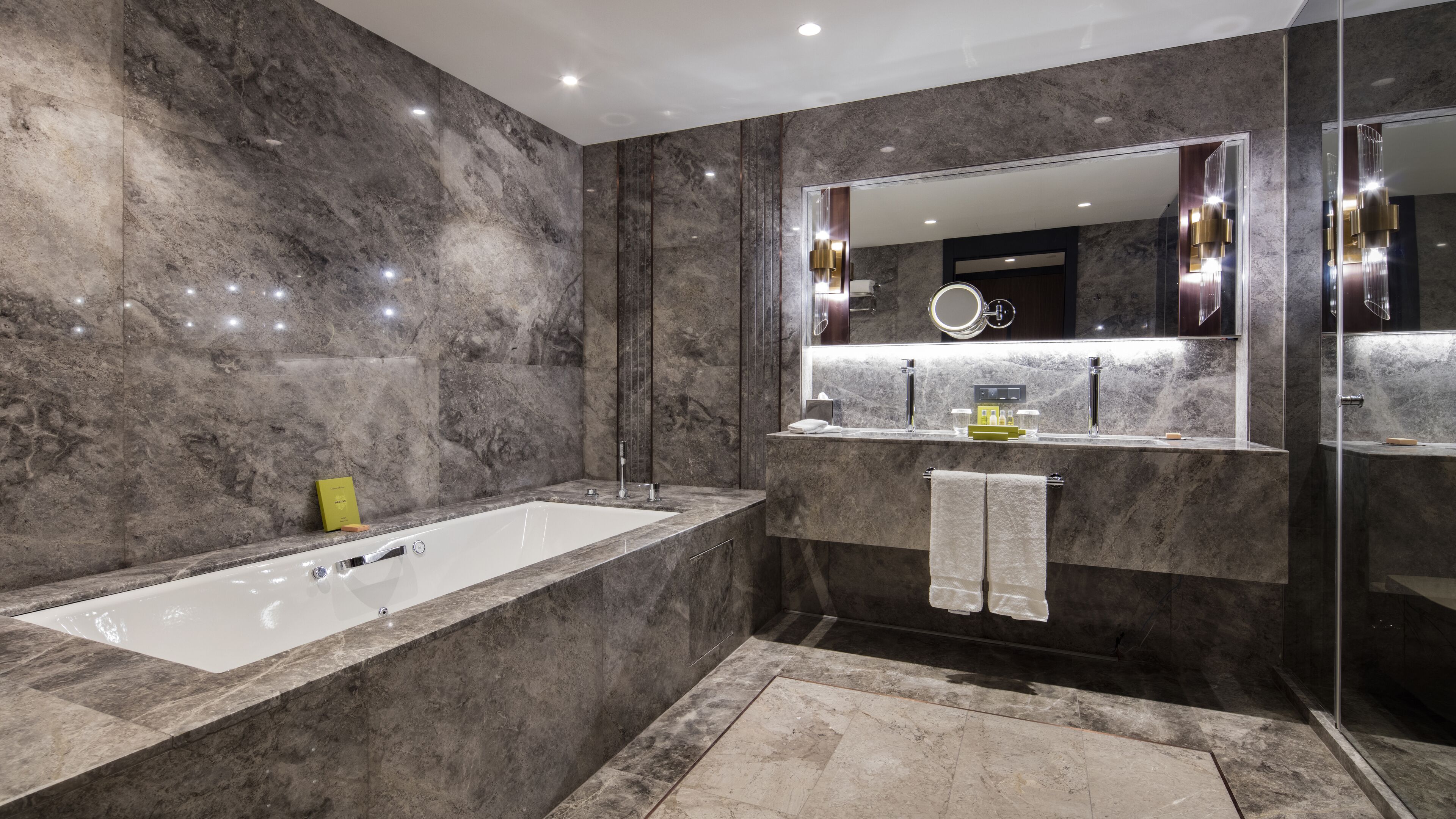 Une salle de bain moderne avec une grande baignoire, un meuble-lavabo avec un miroir et un espace douche.